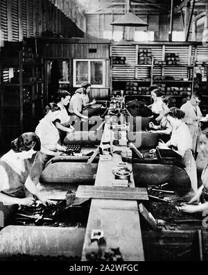 Photograph - Female Workers in Core Shop, Sunshine, Victoria, Feb 1940, Black and white photograph of women working in the Core Shop at the H.V McKay Massey Harris factory during World War Two. More than 20 workers (mostly women) were employed in this department during peak production. The cores were used in foundry process for making castings. A special mix of sand was hand-rammed into metal core boxes which were then split to remove the sandcore. They were then Stock Photo