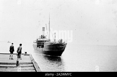 Negative - Two Boys Waiting for the SS Edina Coming into Cunningham Street Pier, Geelong, Victoria, 1937, The Edina was one of the longest serving steam vessels anywhere in the world. Built on the Clyde in 1854 by Barclay, Curle & Co. she was an iron-hull single-screw steamer of 322 tons. During her early career the Edina served primarily in coastal waters around the United Kingdom, apart from brief stints as a stores ship for the Cirmean War in 1855, and as a blockade runner for the Confederate Stock Photo