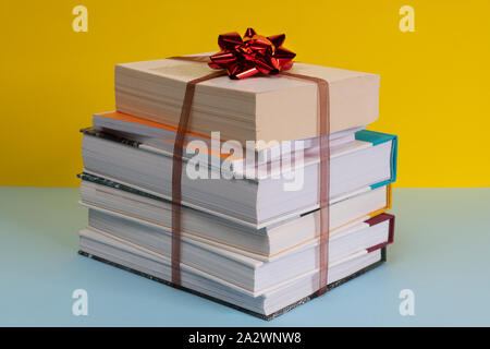 the gift of a pile of books bound by a ribbon and a bow Stock Photo