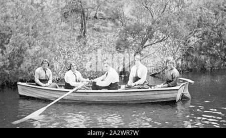 Negative - South Australia, 1914, A man and four women in a rowing boat. Three of the women (one of whom is rowing) wear long sleeved shirts and ties and may be students Stock Photo