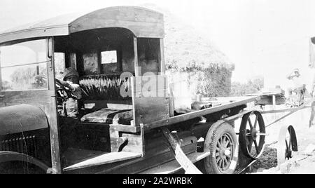 Negative - Manangatang, Victoria, circa 1925, Cutting chaff using a truck as the power source . A child is sitting in the driver's seat of the truck Stock Photo