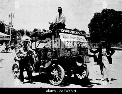 Negative - Castlemaine, Victoria, circa 1920, Bob Birtles on his trip around Australia posing with his Model T Ford vehicle and two other men. The rear of the vehicle is loaded with equipment including four gallon tins of petrol. A large sign is fixed to the back of the vehicle advertising the trip Stock Photo