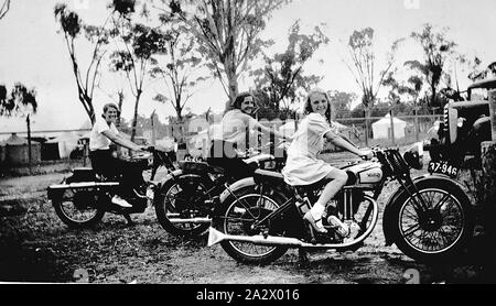 Negative - Bendigo, Victoria, 1937, Three girls seated on motorcycles including a Norton and a Matchless. There are tents in the background Stock Photo