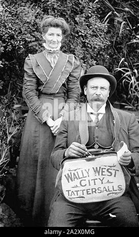 Negative - Melbourne, Victoria, circa 1900, A bookmaker and his wife in a garden. He is holding a bookmaker's bag with the legend'Wally West, City, Tattersalls Stock Photo