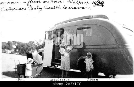 Negative - Victorian Baby Health Caravan, Walpeup District, Victoria, 1939, The Victorian Baby Health Caravan between Walpeup and Galah. A woman holding a baby and two small children stand beside the caravan Stock Photo