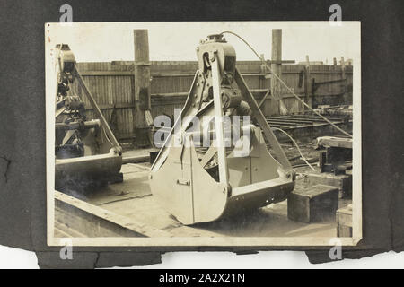 Photograph - A.T. Harman & Sons, Closed Excavator Bucket in a Yard, circa 1923, One of three black and white photographs attached to an album page. Part of a group of five album pages and three loose photographs depicting excavators, winches and other industrial equipment manufactured by A.T. Harman & Sons. Part of a collection of photographs, film, engineering drawings, trade literature and business papers relating to the operations of the Victorian engineering firm A.T Stock Photo