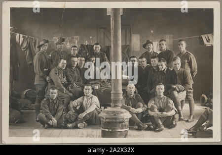 Photograph - Soldiers in a Room, World War I, circa 1917-1918, Photograph of a group of men in military uniform. Their appearance indicates that the photograph was taken during World War I. It has been suggested that the photograph was taken in a billet in France during World War I, perhaps after a spell in the frontline. The diamond patches represent battalions from the 2nd Australian Division. The man on the far left is wearing three chevrons on his Stock Photo