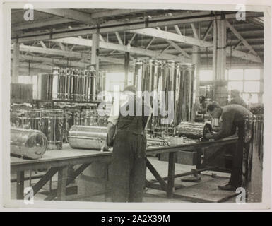 Photograph - Hecla Electrics Pty Ltd, Factory Workers Assembling Water Cylinders, circa 1920, Black and white photograph of Hecla employees assembling water cylinders, possibly taken at the Little Collins Street factory in Melbourne, circa 1920s. The dress of the workers indicates that the image was taken in the 1920s, a time when the focus of the business was shifting from radiators, lighting and art metal to domestic appliances. The manufacturing equipment is simple, and finishing Stock Photo