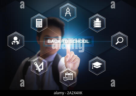 School boy wearing in school uniform and back pack bag pressing the button Back to school using hologram Stock Photo