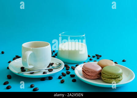 Multicolored macarons white a cup of coffee or tea. breakfast with dessert Stock Photo