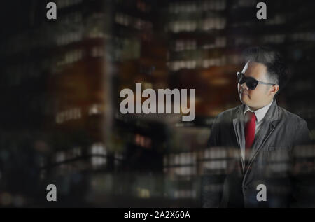 A young handsome business man in formal corporate attire standing in the right side of the frame and looking at the left side. Stock Photo