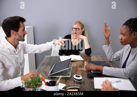 Female Colleagues Looking At Male Executive Discussing Project Plan In Meeting Room Stock Photo