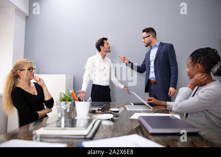 Dissatisfied CEO Shouting At His Young Male Worker For Bad Performance In Front Of Coworkers Stock Photo