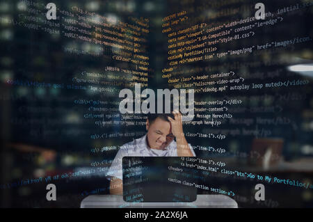 Young male web developer getting angry and frustrated while working on his project. Working at night shift. HTML Codes. Stock Photo
