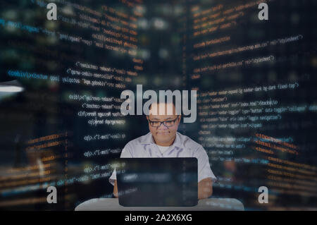 Serious working web developer. Working at night shift. Web developer working at night with random HTML codes overlay. Stock Photo