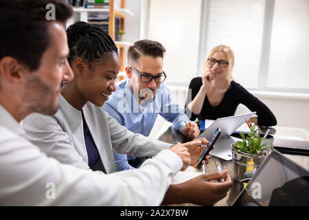 Young Multi Ethnic Businesspeople Using Mobile Phone During Office Meeting Stock Photo