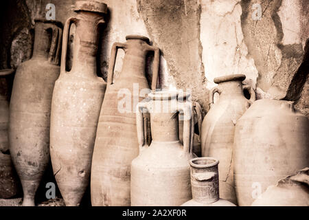 Antique ceramic jugs, pots and vases in ancient city Ercolano of roman times ruined by volcano Vesuvius in Italy Stock Photo
