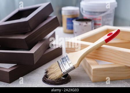 Brown color stain painting on wooden frames use for art paintings, photos and other visual works. Paintbrush, wooden frames, paints on table. Stock Photo