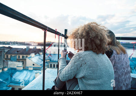 two teenagers girl friends having fun on roof top, liestyle people traveling europe concept