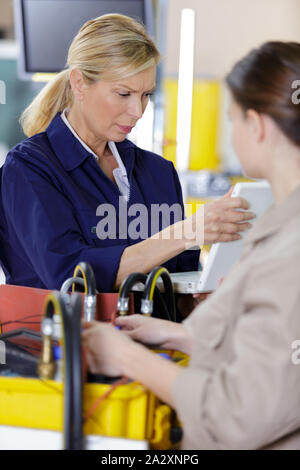 female trainer inspecting information from the tablet Stock Photo