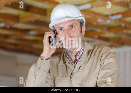 builder in helmet talking on walkie talkie Stock Photo