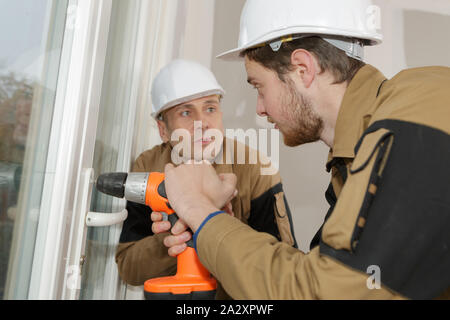 construction workers installing window in house Stock Photo