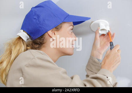 portrait of an electrician installing ceiling lights Stock Photo