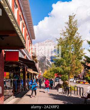 Banff Avenue, busy with tourists on a sunny fall day with a large mountain seen in the distance, Banff, Alberta, Canada Stock Photo