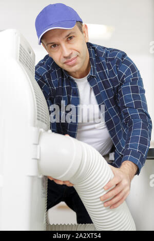 worker connecting pipes to air conditioning system Stock Photo