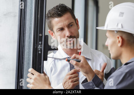 smiling man is fixing a window handle Stock Photo