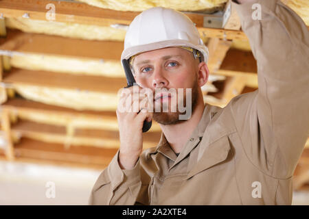 male construction worker using walkie talkie in property Stock Photo