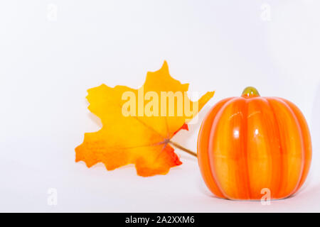 Bright orange and yellow festive maple leaf and pumpkin ornament on an isolated white background for fall thanksgiving and halloween season. Stock Photo