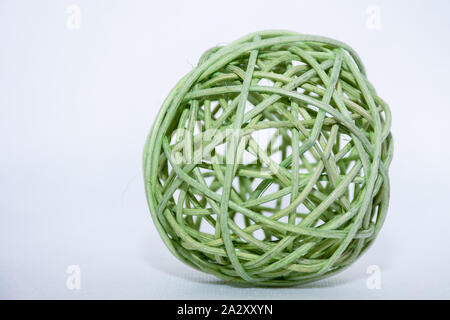 Green wicker reed like ornament or decoration ball on an isolated white background. Fall or winter season. Stock Photo
