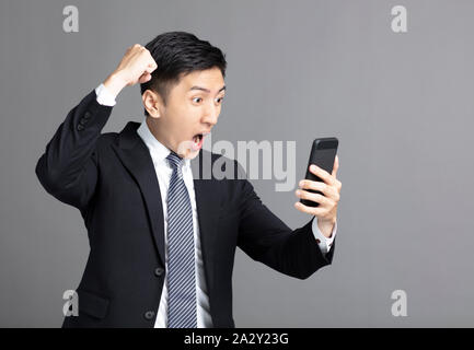 surprised young business man watching the mobile phone Stock Photo