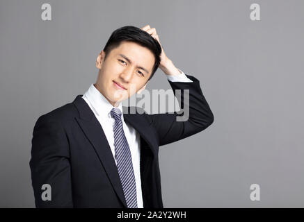 confused young businessman scratching his head Stock Photo