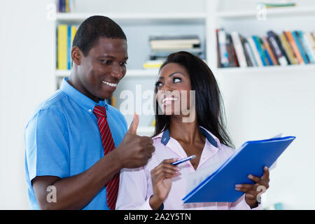 African american business man complimenting female trainee at office of company Stock Photo