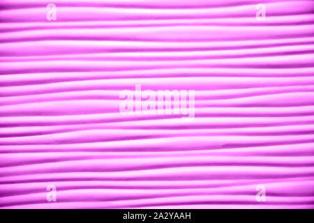 Close-up of artificial textured surface with simple wave pattern toned in shades of lilac color. Plenty of smooth horizontal wavy lines. Empty abstrac Stock Photo