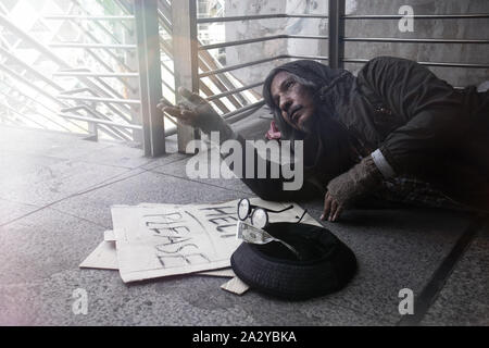 Homeless people living in various cities He waited and needed help from the kind people to give him all the necessary things, clothing, bread, water, Stock Photo