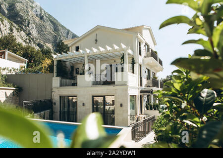 View of the white mansion with a balcony and windows or a residential building or dwelling. Stock Photo