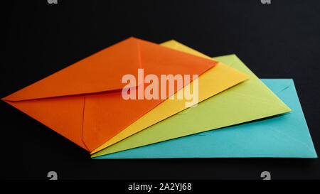 Greeting card, holiday decorations, colorful envelopes isolated on black background,angle view Stock Photo