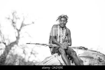 Lake Eyasi, Tanzania, 11th September 2019: Hadzabe man resting with his bow and arrow Stock Photo