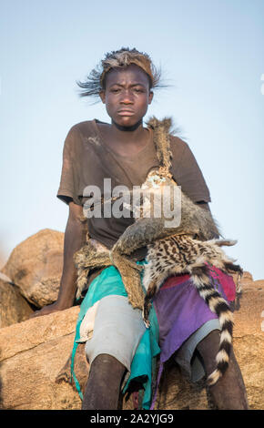 Lake Eyasi, Tanzania, 11th September 2019: Hadzabe young man in animal fir clothing, resting Stock Photo