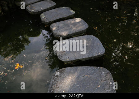 Artificial stone bridge across a small creek Stock Photo