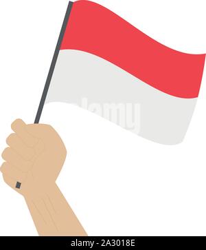 Hand holding and raising the national flag of Indonesia Stock Vector