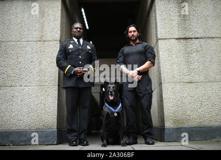 Handler Officer Marshall Mirarchi (right), and Richard Macauley, Deputy Chief of Special Operations for the US Secret Service (USSS), with US Secret Service dog, Special Operations Canine, Hurricane, as the 10 year old Belgian Malinois receives a PDSA Order of Merit at the County Hall Hotel in London. Stock Photo