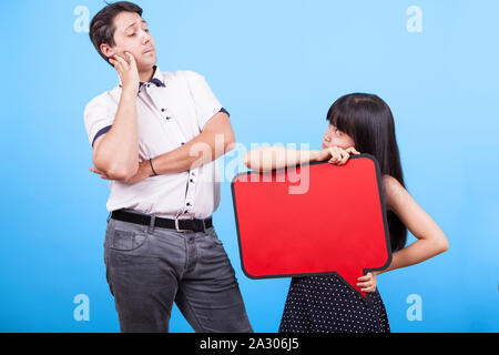 Asian girlfriend holding blanks bubble thought while her boyfriend looks at her. Interracial couple. Stock Photo