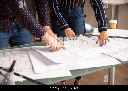 Close up of two architects hands pointing at some drawings. Young person and new ideas Stock Photo