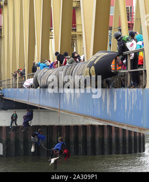Hamburg, Germany. 04th Oct, 2019. Climate activists abseil from the Kattwyk bridge in Hamburg harbour. About one hundred climate activists have occupied the Kattwyk Bridge in the Port of Hamburg and paralyzed traffic for several hours. Under the motto 'deCOALonize Europe', they demanded the immediate withdrawal from lignite and hard coal as well as the closure of all coal-fired power plants in Hamburg and the coal port in Hamburg. (to dpa 'Protest against coal-fired power plant Moorburg - activists occupy bridge') Credit: Magdalena Tröndle/dpa/Alamy Live News Stock Photo