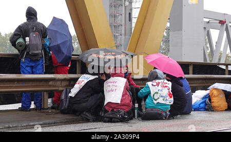 Hamburg, Germany. 04th Oct, 2019. Climate activists block the roadway of the Kattwyk Bridge. About one hundred climate activists have occupied the Kattwyk Bridge in the Port of Hamburg and paralyzed traffic for several hours. Under the motto 'deCOALonize Europe', they demanded the immediate withdrawal from lignite and hard coal as well as the closure of all coal-fired power plants in Hamburg and the coal port in Hamburg. (to dpa 'Protest against coal-fired power plant Moorburg - activists occupy bridge') Credit: Magdalena Tröndle/dpa/Alamy Live News Stock Photo