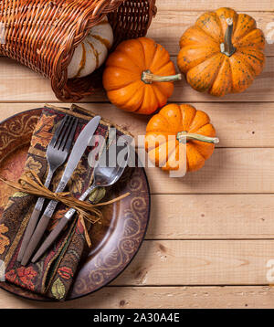 Overhead view of an utumn place setting and mini pumpkins on a rustic wooden table Stock Photo